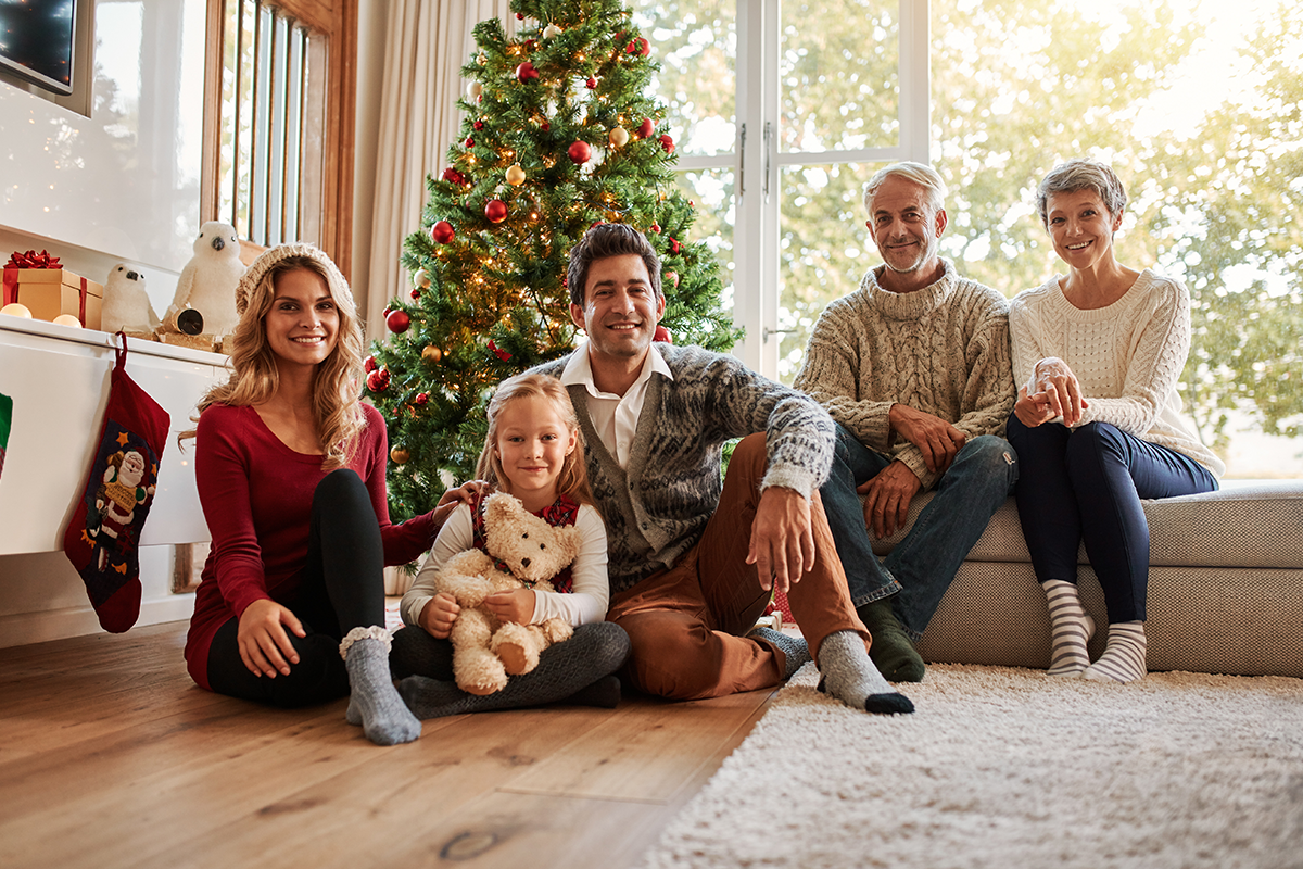 Portrait of multi generation family in front of Christmas tree | Photo by Jacob Lund via Shutterstock