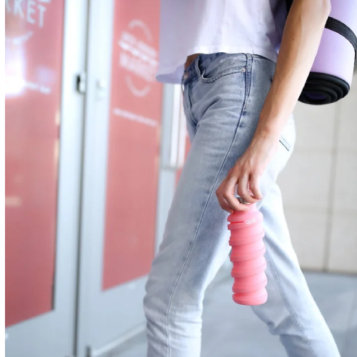 Side view of Que Bottle, 20oz Collapsible Bottle - Coral Pink